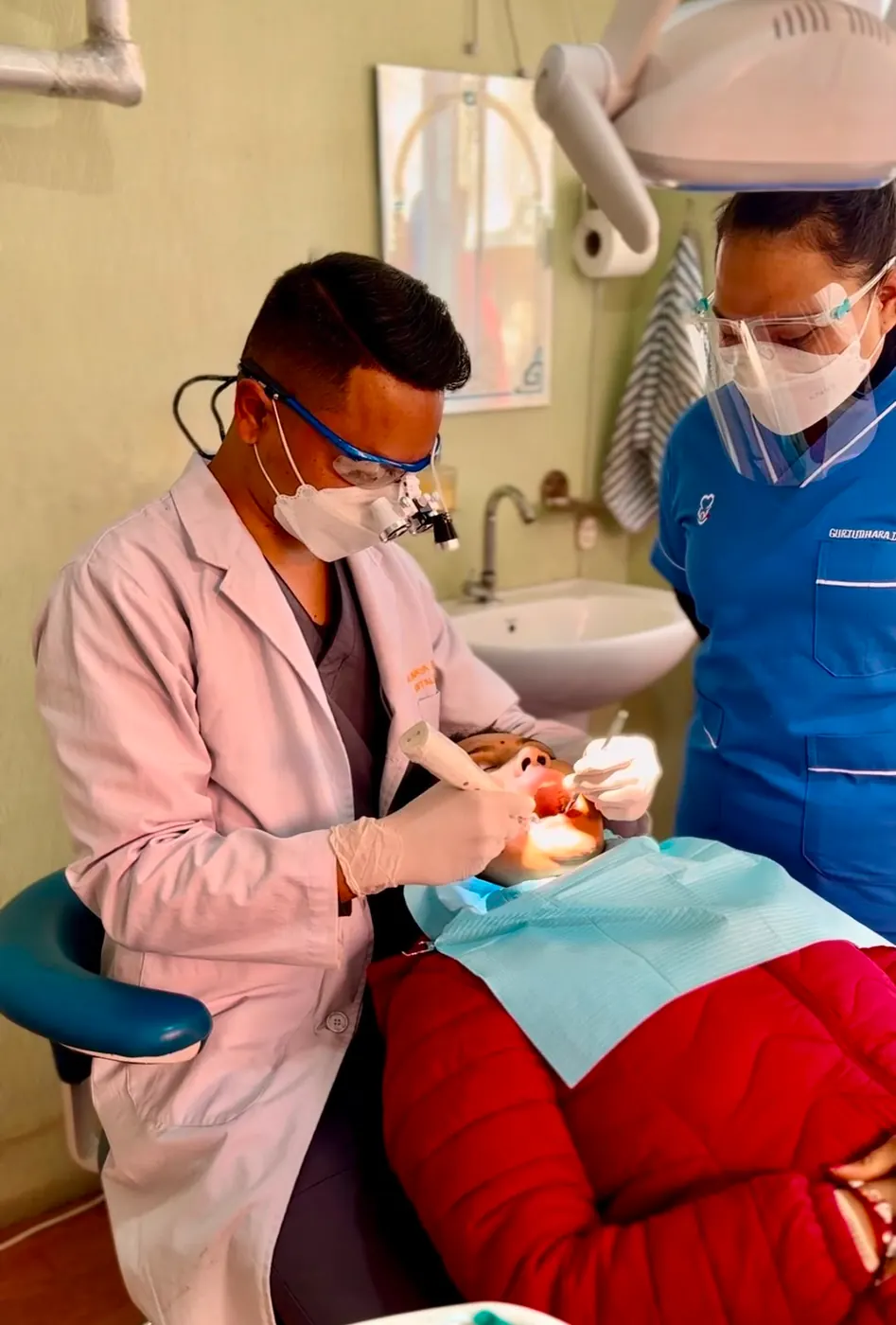 Dentist and dental assistant treating a patient together at Gurjudhara Dental Care, Chandragiri-12