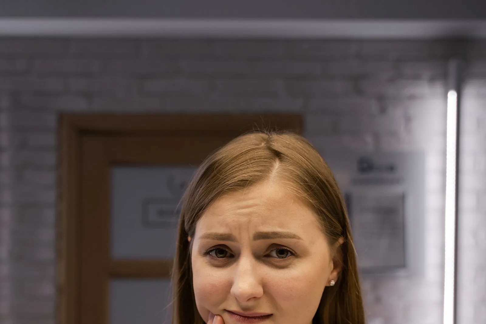 Woman holding her cheek in pain from severe toothache needing emergency dental care