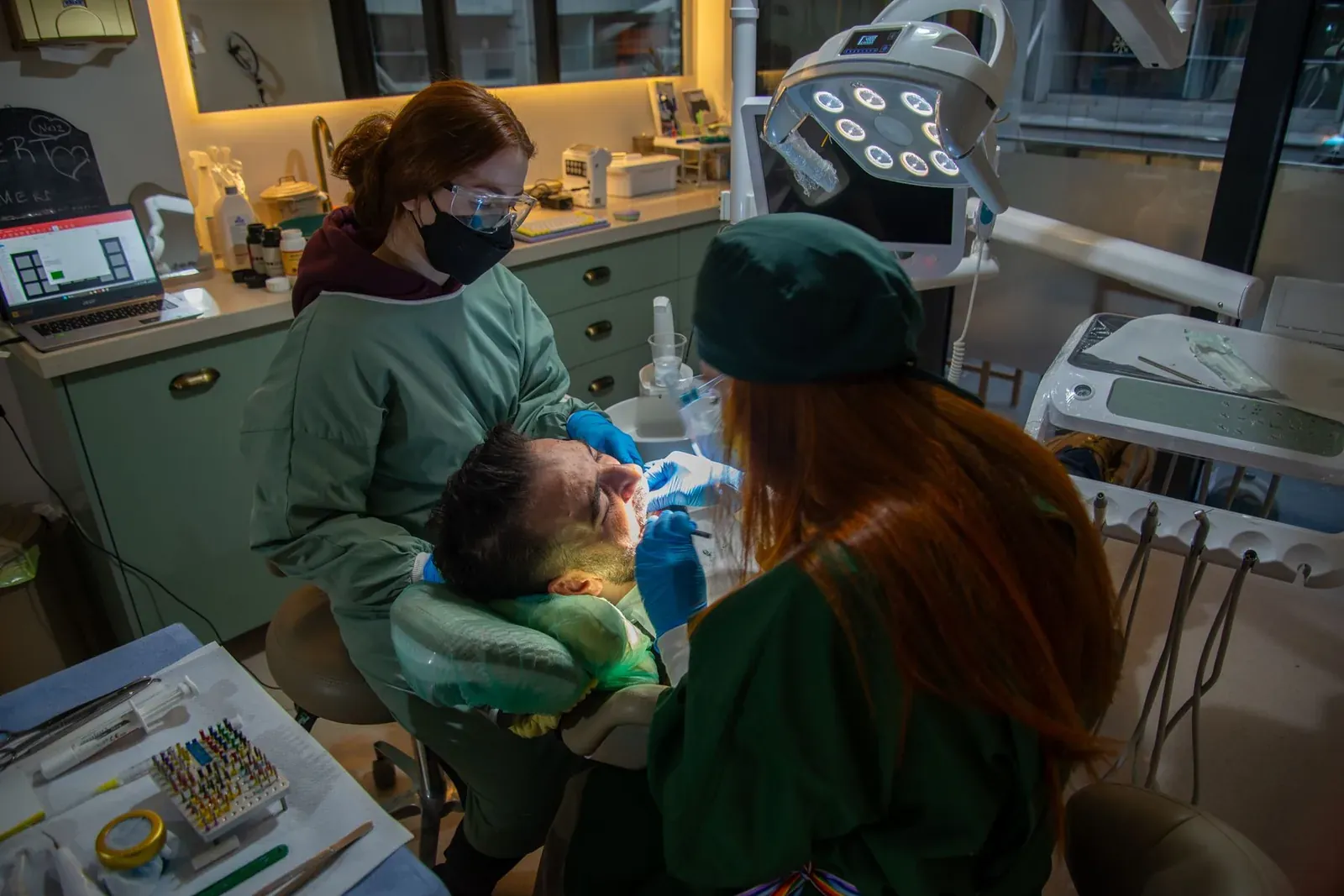 Two clinicians carrying out periodontal gum surgery on a patient under local anaesthetic