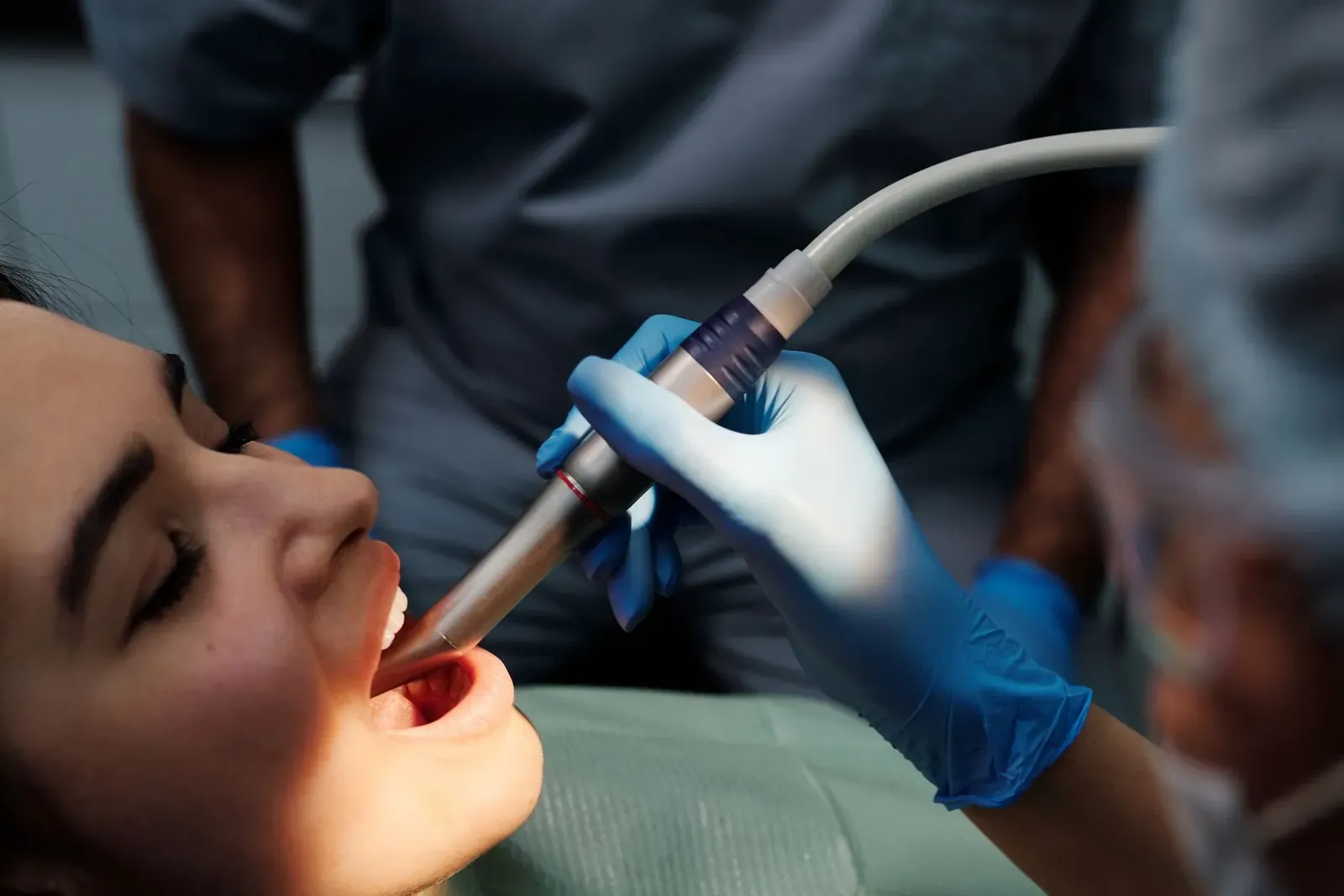 Ultrasonic scaler removing plaque and tartar from a patient's teeth during scaling and polishing